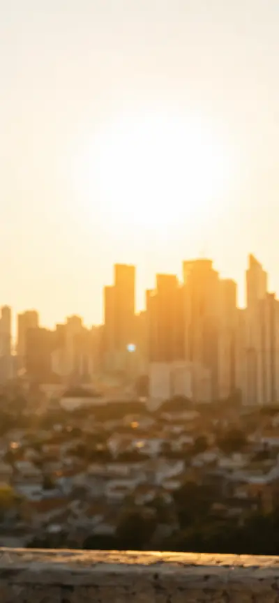 termômetro marcando temperatura elevada sob sol forte em área urbana brasileira